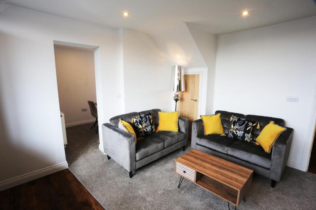 a living room with two couches and a coffee table at Hotl Aparts at The Deal House in Kirkheaton