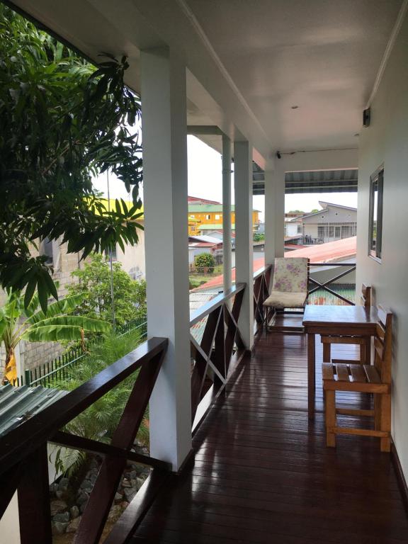 Un balcón con una mesa y una silla. en Asteria Studios, en Paramaribo