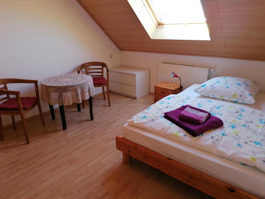 Schlafzimmer mit einem Bett, einem Tisch und Stühlen in der Unterkunft Ferienwohnung Suedbalkon in Friesenheim