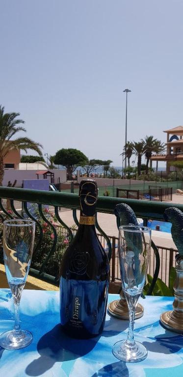 a bottle of wine sitting on a table with two glasses at PLAYA LAS VISTAS LOFT in Los Cristianos