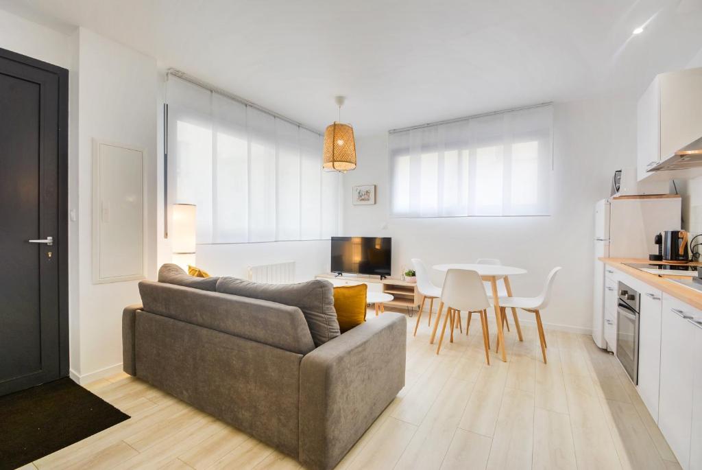 Una sala de estar con un sofá y una cocina con una mesa. en L'indépendant de la rue du Tapis Vert - Appt Nancy, en Nancy