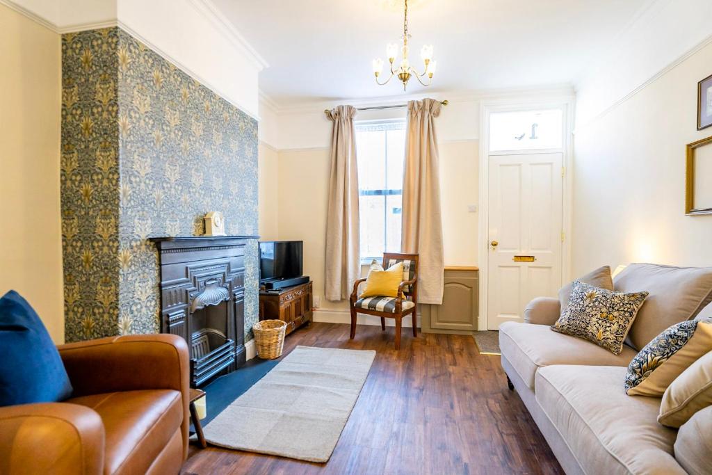 a living room with a couch and a fireplace at Victoria Cottage in York
