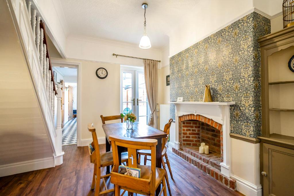 uma sala de jantar com uma mesa e uma lareira em Victoria Cottage em York