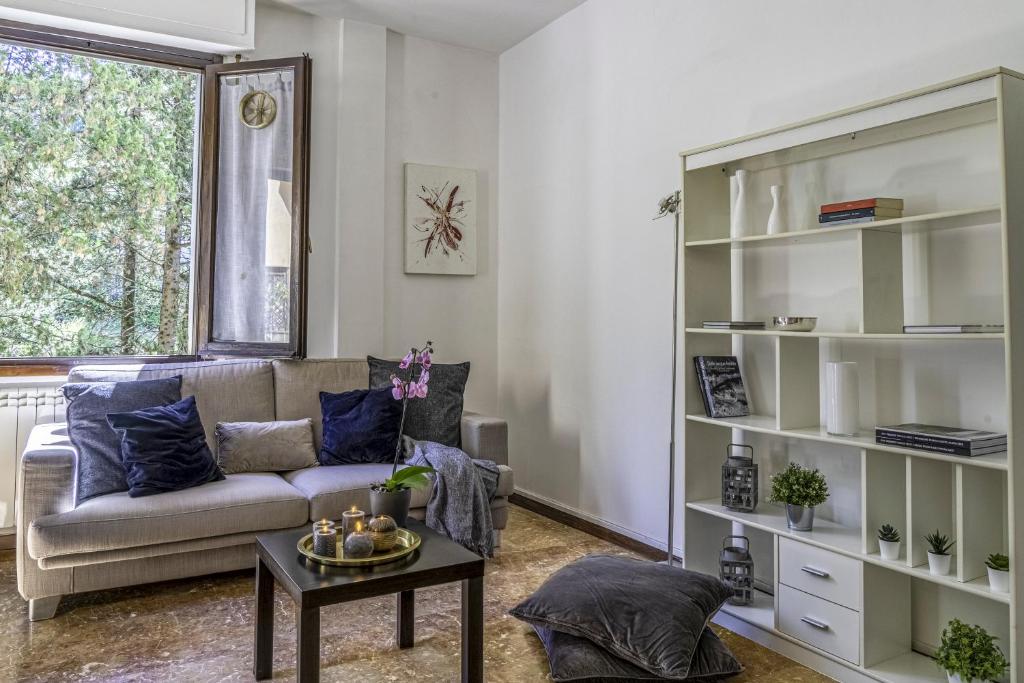 un soggiorno con divano e tavolo di Cozy Roman Apartment with parking a Firenze
