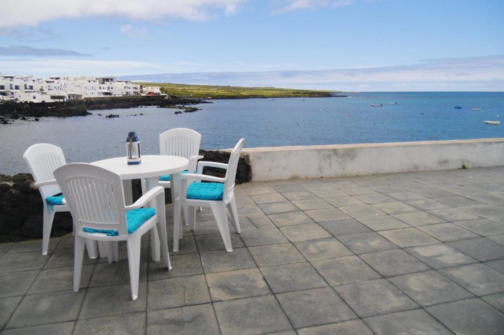 a table and chairs on a patio overlooking the water at El Muellito Ocean View in Punta de Mujeres