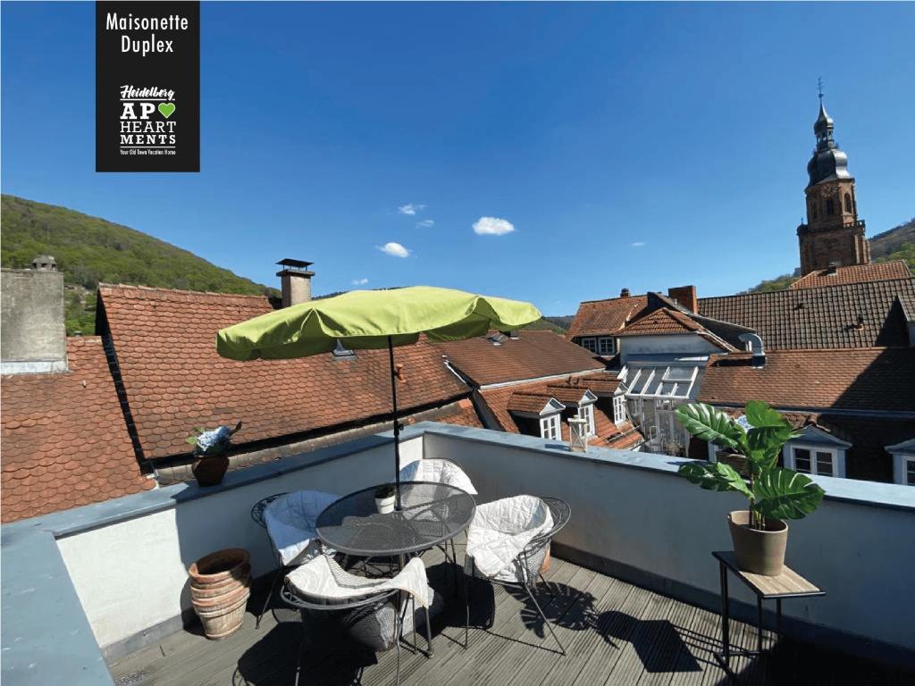 un patio avec une table et un parasol sur le toit dans l'établissement Heidelberg Apheartments, à Heidelberg