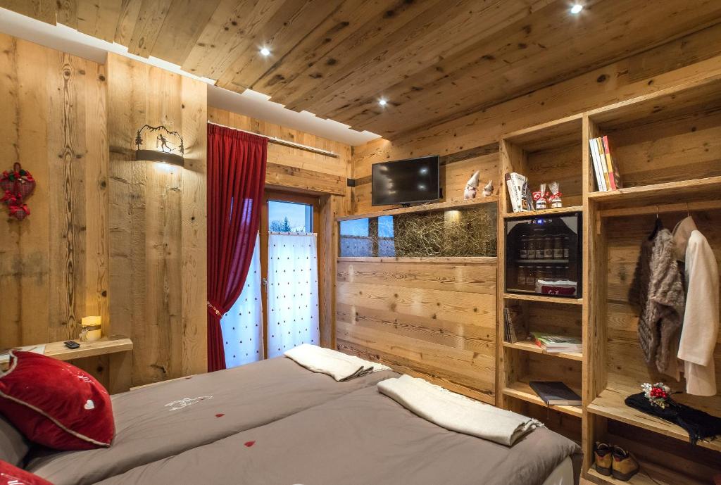 una camera con pareti in legno e un letto in una stanza di AGRITURISMO La Giasena a Ponte nellʼAlpi