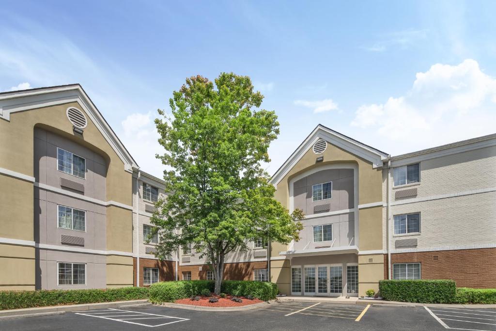 an apartment building with a tree in a parking lot at Candlewood Suites Huntersville-Lake Norman Area, an IHG Hotel in Huntersville