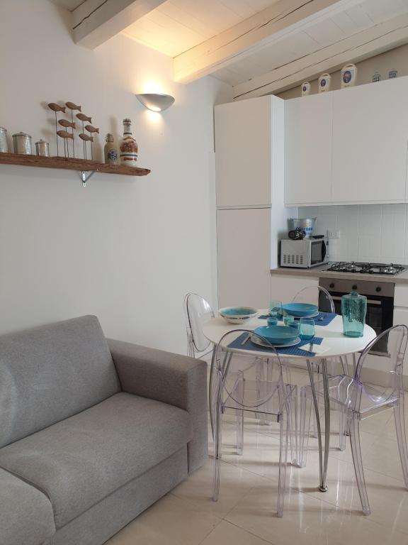 salon z kanapą, stołem i krzesłami w obiekcie Cottage al mare Martina w Lido di Venezia