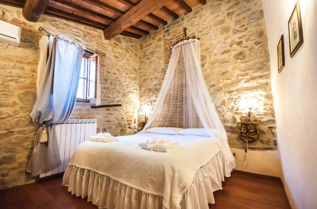 Schlafzimmer mit einem Bett mit Moskitonetz in der Unterkunft B&B Antica Gabella in Castiglione del Lago