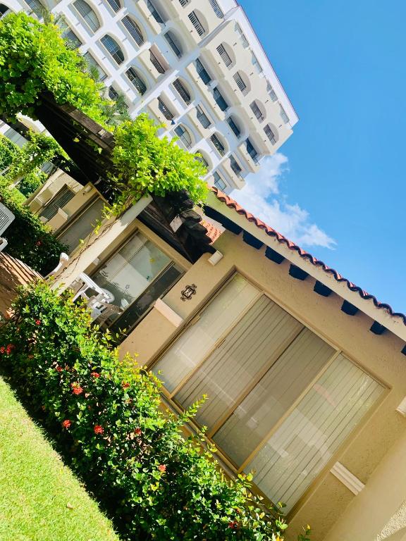 a building with two garage doors and a tall building at HAB PTa B ÁREA DE VILLAS DENTRO DEL HOTEL Junto al Krystal EN IXTAPA WIFI 2A 1M Con playa in Ixtapa