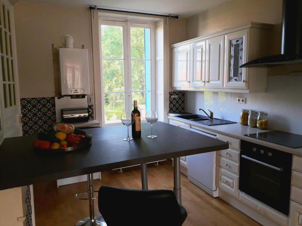 eine Küche mit einem Tisch und 2 Gläsern Wein in der Unterkunft Appartement 80m2 dans belle demeure in Vrigne-aux-Bois
