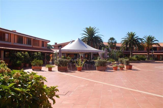 a pavilion with a white tent in a courtyard at Residence Porto Coda Cavallo in San Teodoro