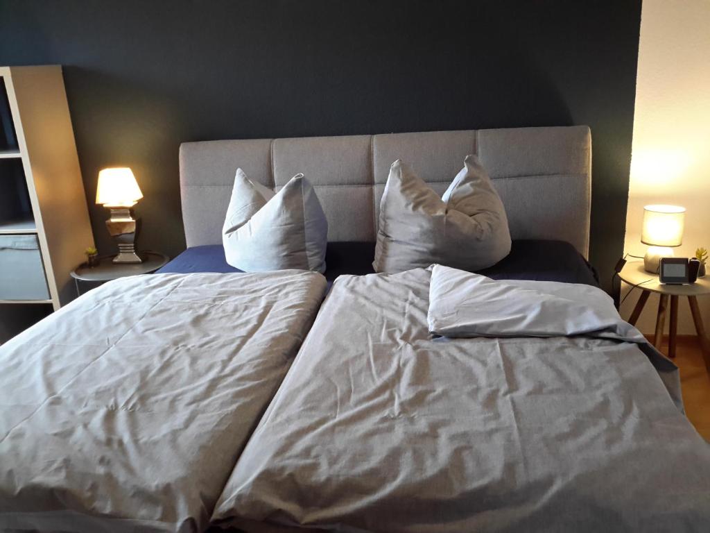 een bed met witte lakens en kussens erop bij Appartement Luthers Stübchen in Lutherstadt Wittenberg