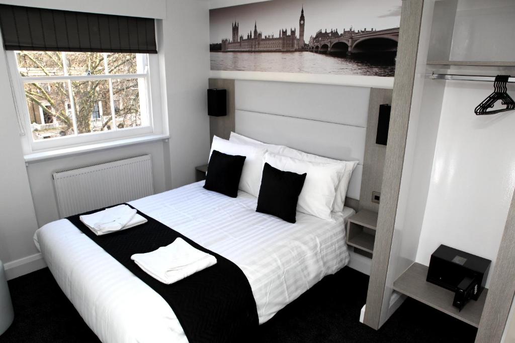a bedroom with a bed with white sheets and pillows at The Omega Hotel in London