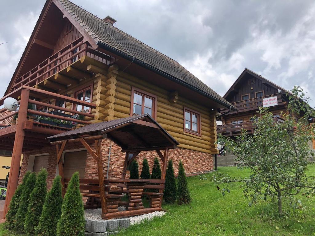 ein Holzhaus mit einem Dach auf einem grünen Feld in der Unterkunft Chata na brehu Liptovskej Mary in Bobrovník
