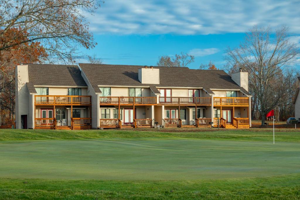 uma casa grande num campo de golfe com um verde em Crown Resorts at Lake Tansi West em Crossville