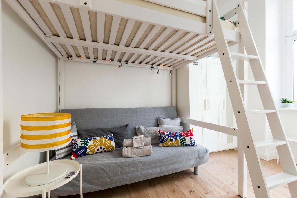 a living room with a couch under a loft bed at Feels like Home in Berlin