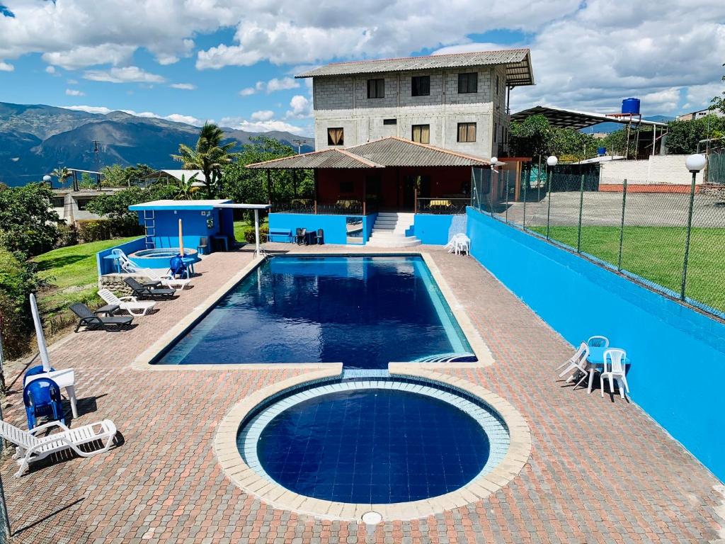 - une piscine avec des chaises et une maison dans l'établissement Hostería Vista Del Valle, à Hacienda Santa Isabel
