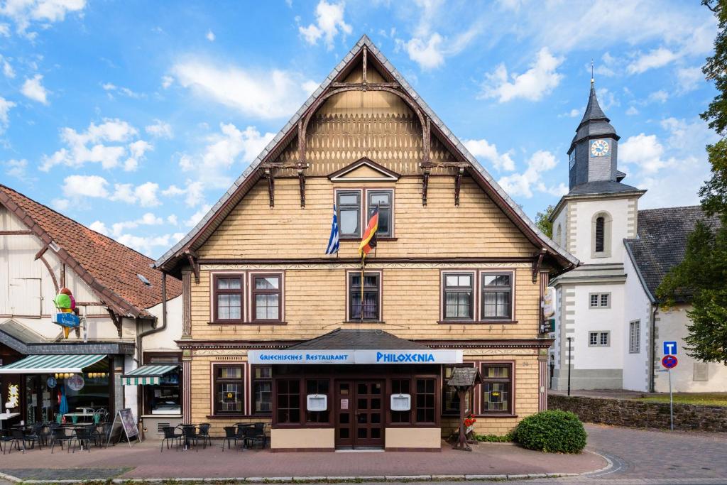 un gran edificio de madera con una torre de reloj en Hotel Deutsches Haus en Aerzen