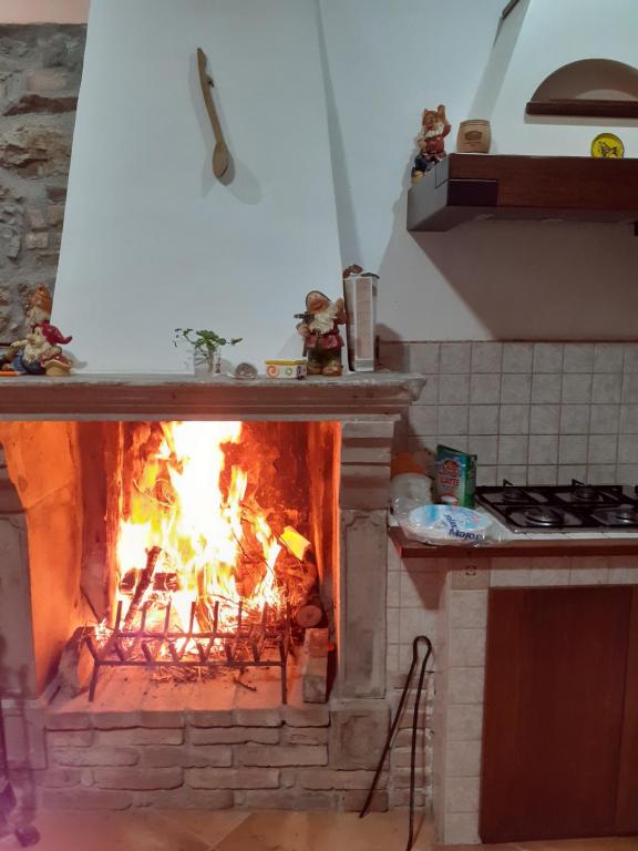 a fireplace in a kitchen with a fire in it at le rondini in Boiano