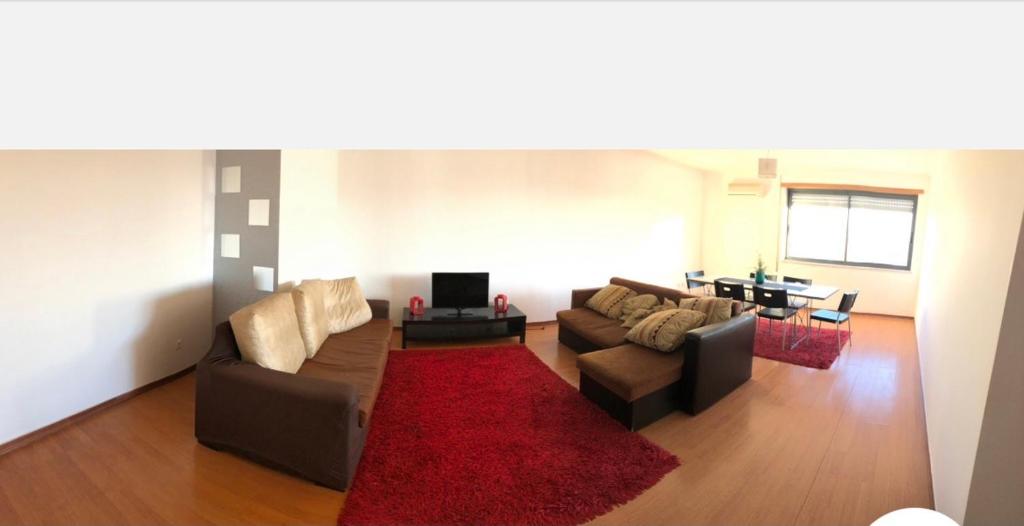 a living room with two couches and a red rug at Wonderful apartament Lisbon in Montijo