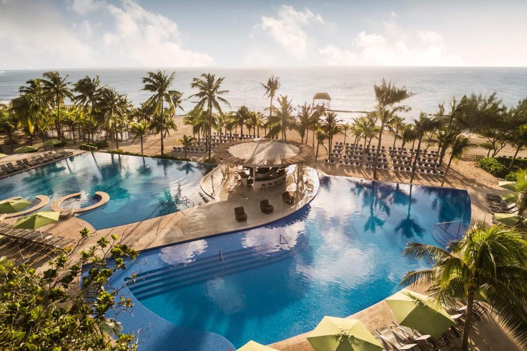 uma vista sobre a piscina na praia em The Fives Beach Hotel & Residences - All Senses Inclusive em Playa del Carmen