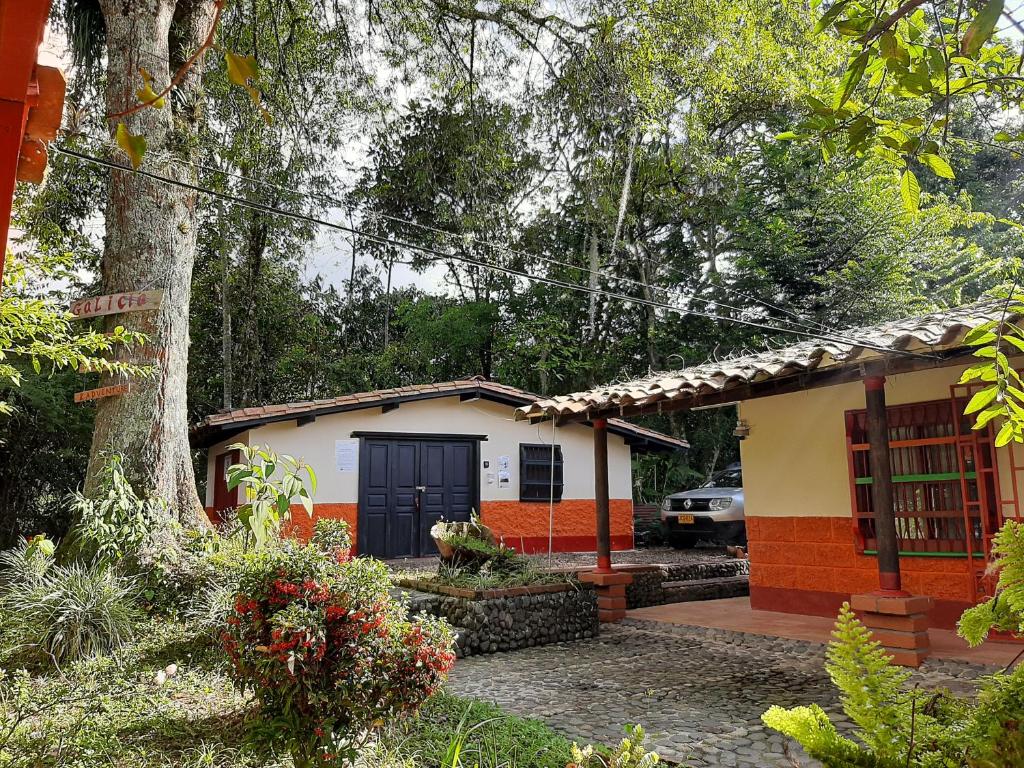 una pequeña casa con una puerta azul en un jardín en Compostela cabaña privada (private cabin for rent) en Jardín