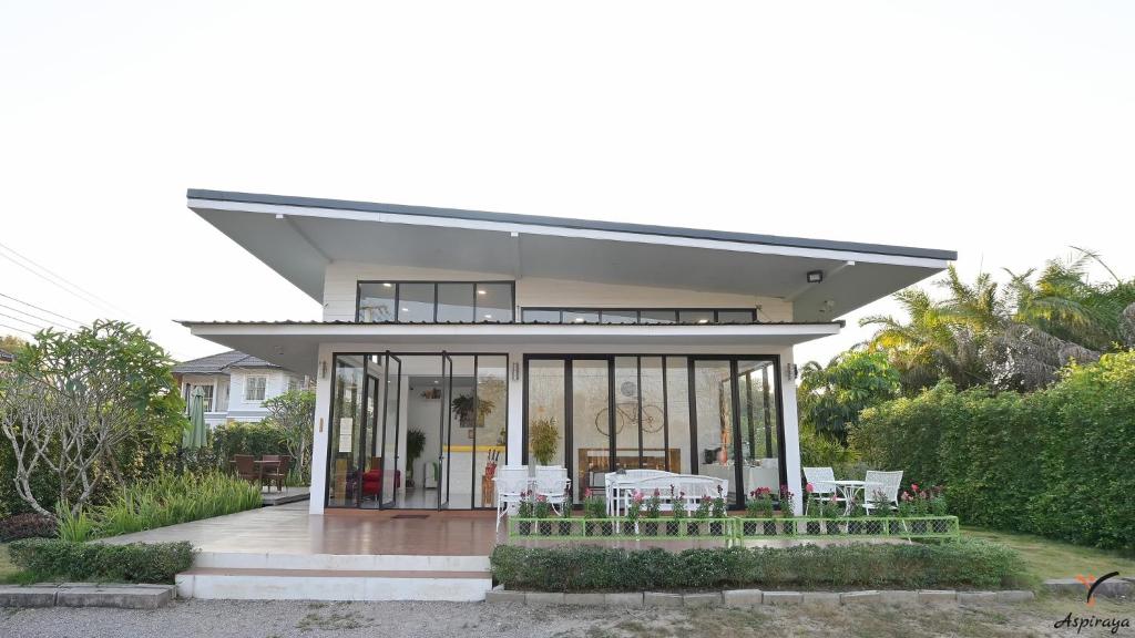 a house with glass doors and a table and chairs at Aspiraya Resort in Chiang Rai
