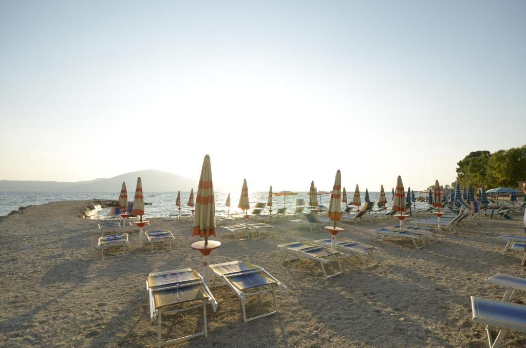 a group of chairs and umbrellas on a beach at Hotel Garden in Vlorë