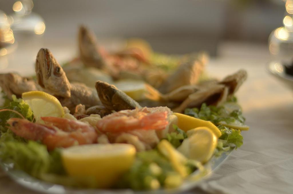 a plate of food with shrimp and vegetables on a table at Hotel Garden in Vlorë