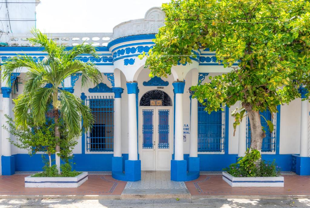 un bâtiment bleu et blanc avec des palmiers devant dans l'établissement Casa Caribe Colonial, à Barranquilla