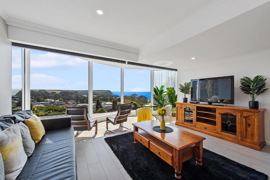 a living room with a couch and a tv at Views Forever - Devonport in Devonport