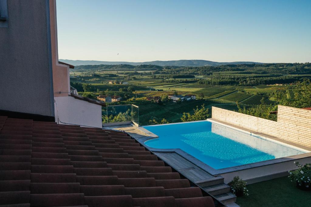 a swimming pool on the side of a house at Bužinel rooms in Dobrovo