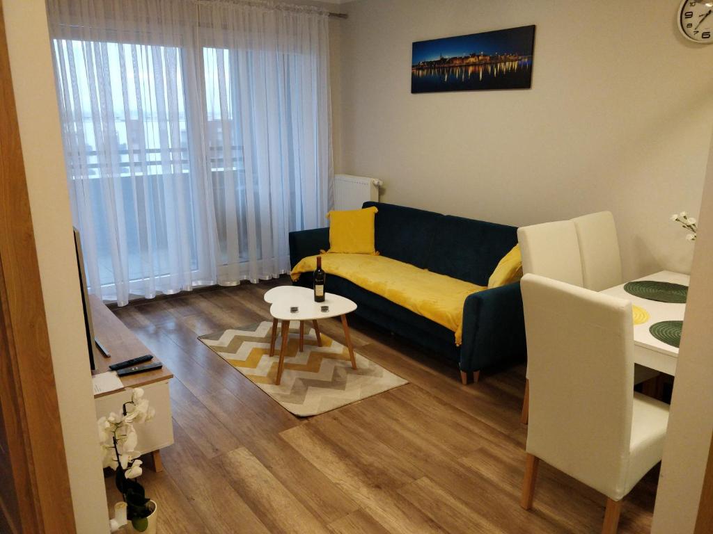 - un salon avec un canapé et une table dans l'établissement Apartament Cukrownia, à Szczecin