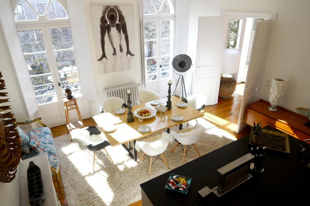 - un salon avec une table et des chaises blanches dans l'établissement Maison Eugénie, à Luchon