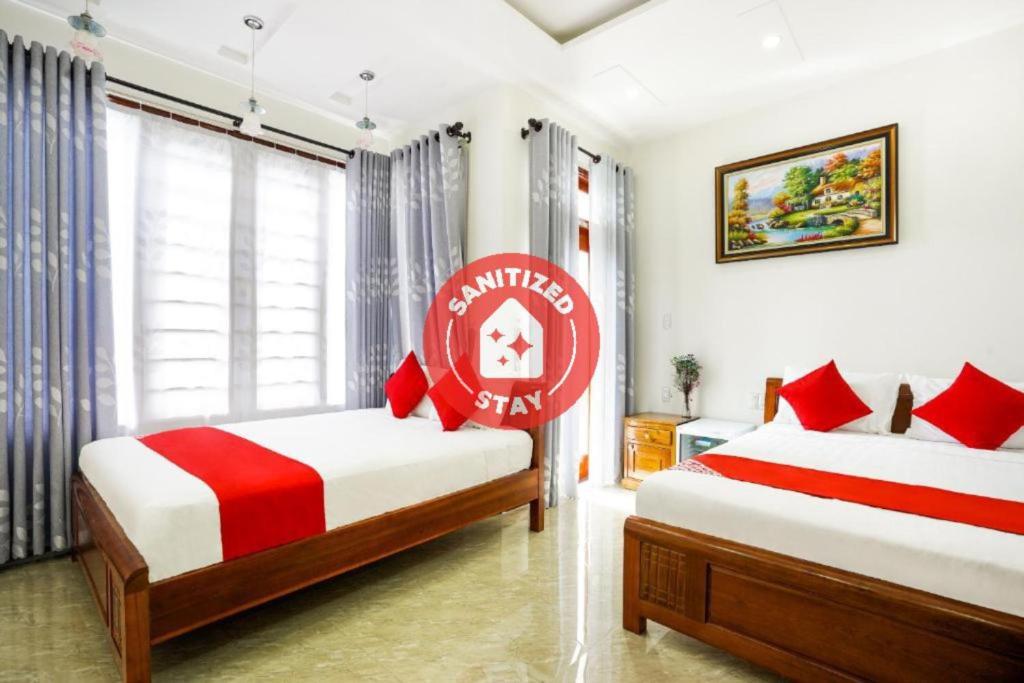 a bedroom with two beds and a red sign on the wall at Legend Connect Homestay in Hoi An