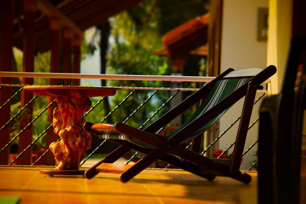een stoel op een veranda naast een tafel bij Prakruthi Home Stay in Sollebail