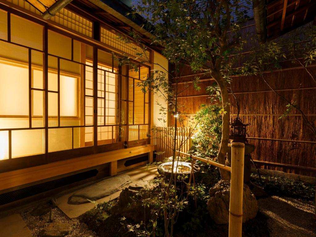 ein Haus mit einem Innenhof mit einem Baum in der Nacht in der Unterkunft Tawara-an in Kyoto