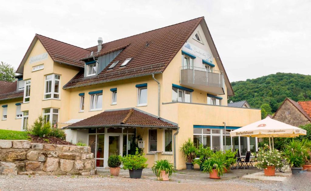 a large yellow building with a brown roof at Hotel Landgasthof Lell in Künzelsau