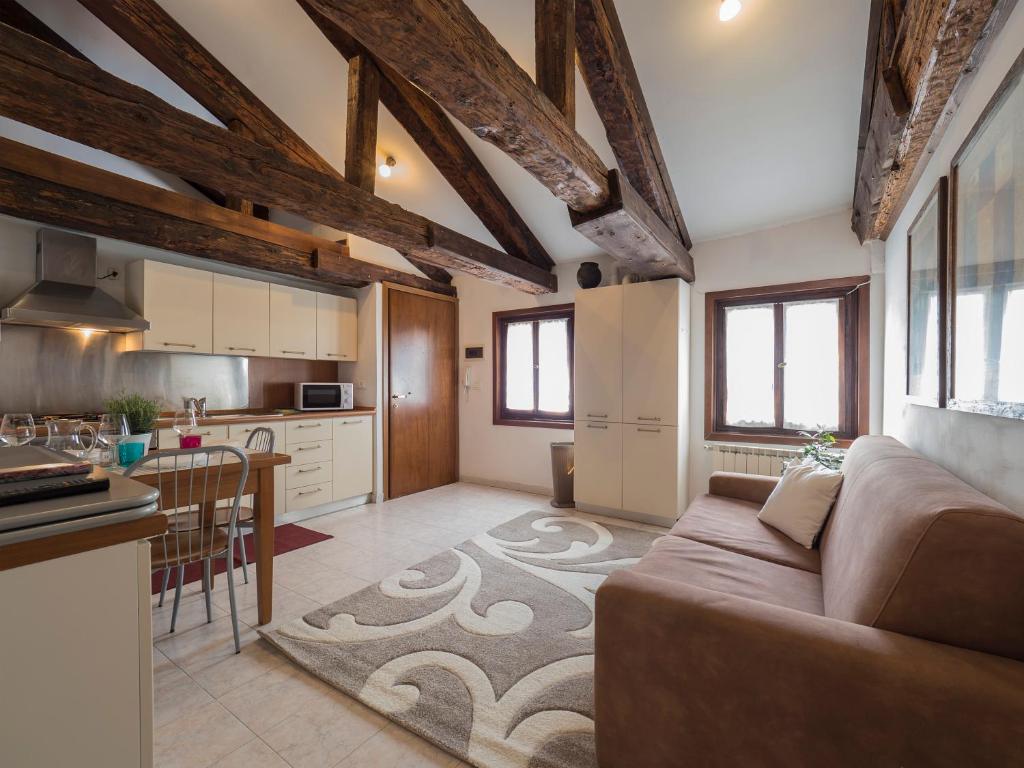 a large living room with a couch and a kitchen at Palazzo Preziosa - Rialto in Venice