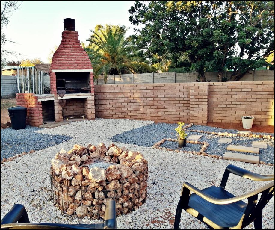 a pile of fire wood next to a brick oven at Ambiente Budget Accommodation in Upington