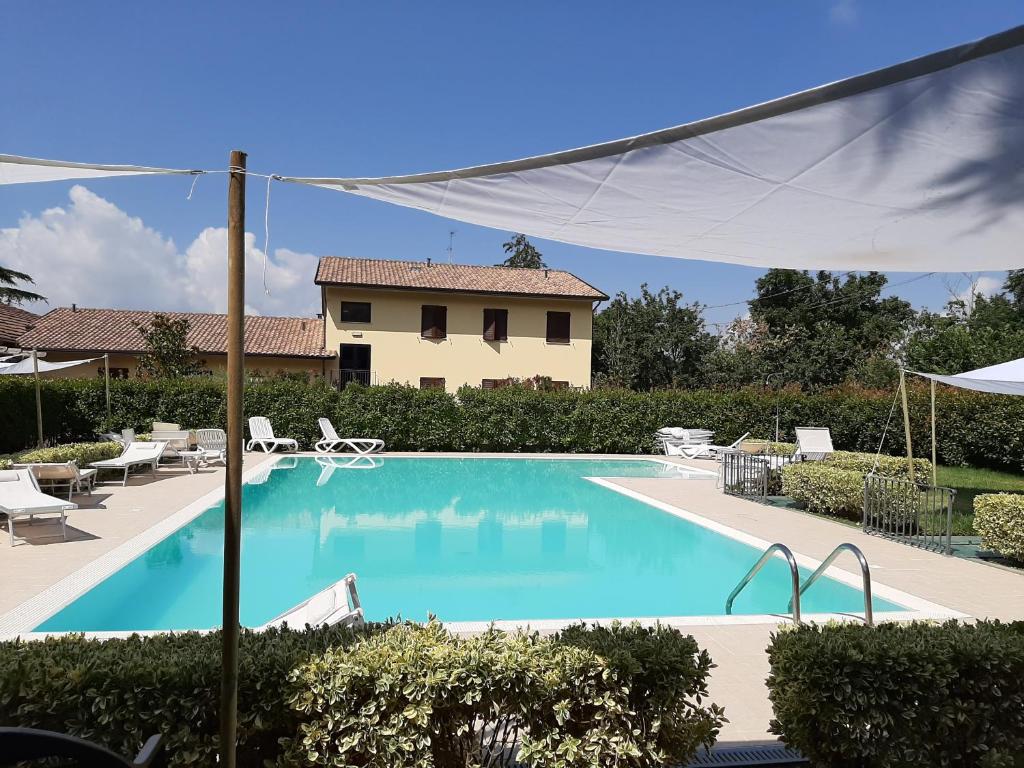 a swimming pool in front of a house at Ostello Victor Center in Capodacqua