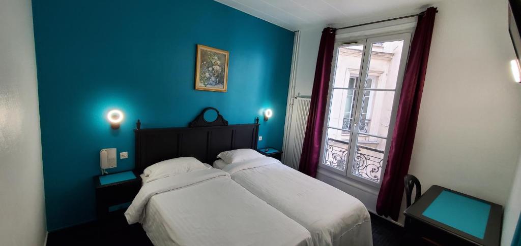 a blue bedroom with a bed and a window at Metropol in Paris