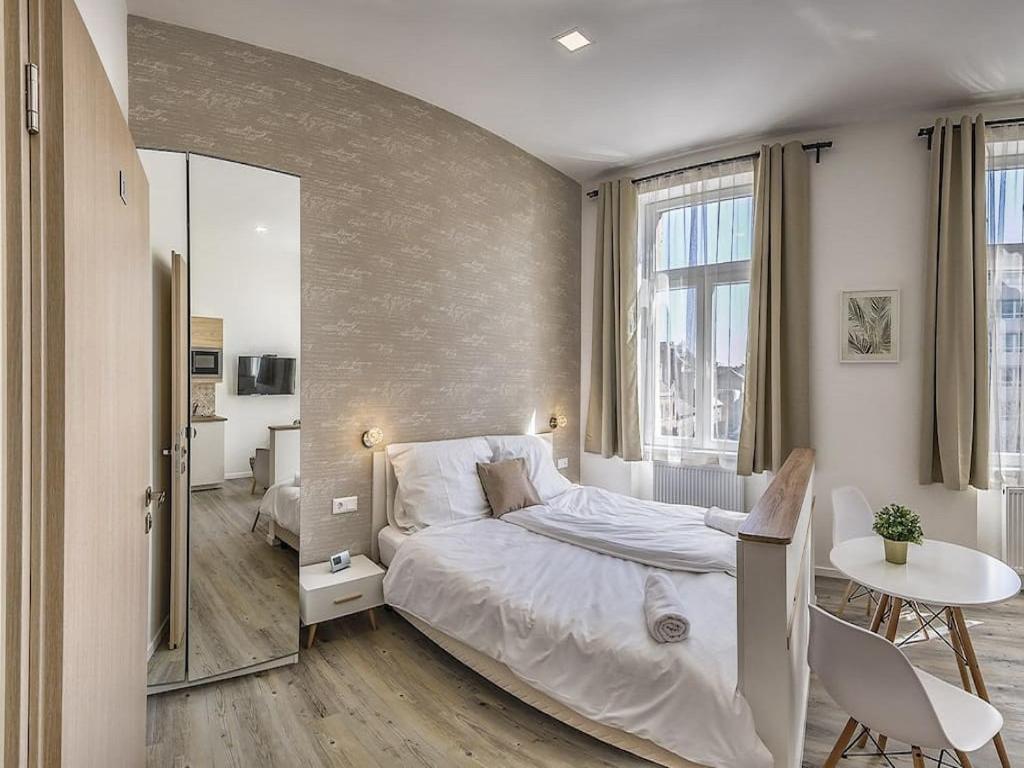 sypialnia z łóżkiem, stołem i lustrem w obiekcie Glam Downtown Apartments w Budapeszcie