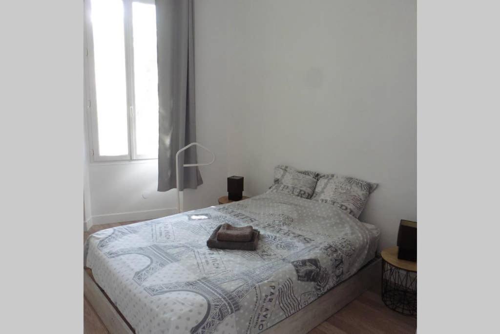 a white bedroom with a bed with a bag on it at Villa Zola in Aix-en-Provence