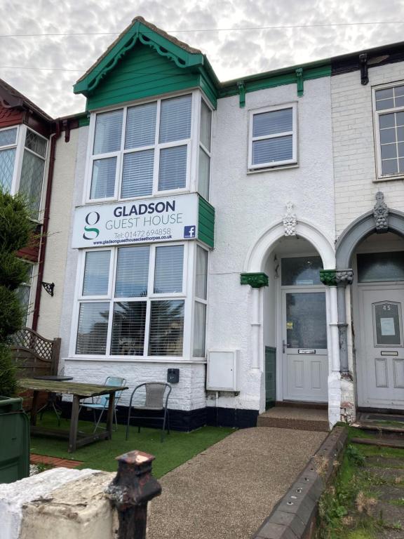 a white building with a sign that reads clason auction house at The Gladson Guesthouse in Cleethorpes