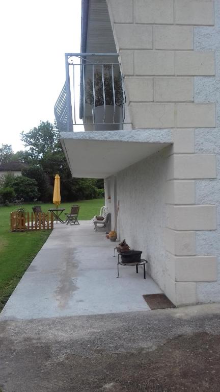 a patio with a balcony on a building at chez sylvette in Quinsac