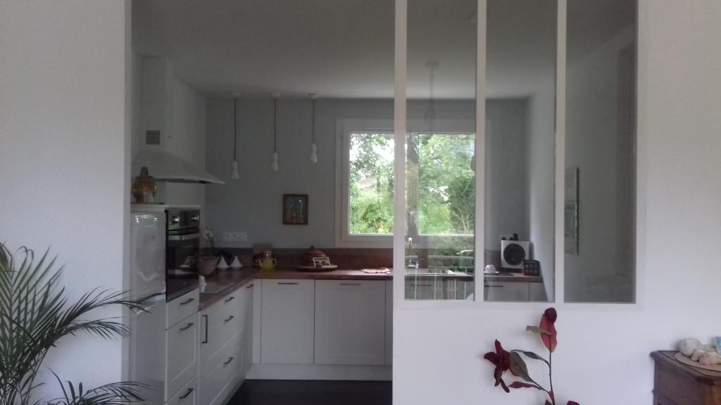 a kitchen with white cabinets and a window at chez sylvette in Quinsac