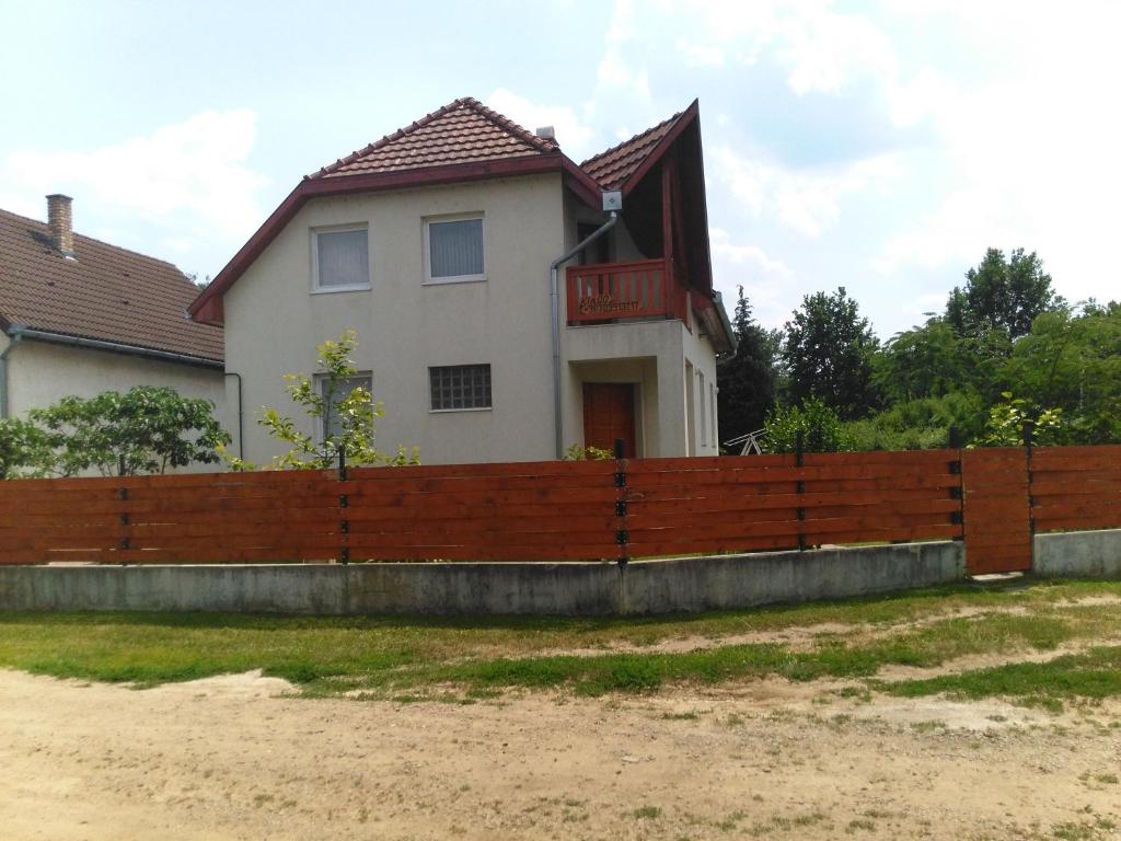 una valla de madera frente a una casa en Sarkifény Vendégház, en Vásárosnamény